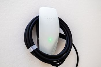 a tesla power adapter plugged into a wall with a charging cable